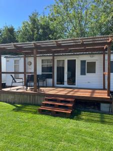 a house with a wooden deck with a picnic table at Domki Dolce Vita in Jastarnia