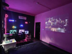 a purple room with a bed and a desk with monitors at VV House and Cinema 2 in Quy Nhon