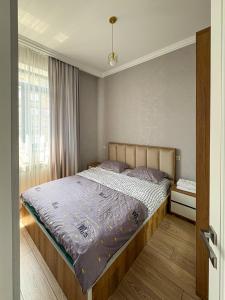 ein Schlafzimmer mit einem großen Bett mit blauer Bettdecke in der Unterkunft Luxury Leo Apartment Sevan in Sewan