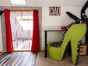 a room with a green chair and a table and a window at Ady Házikó in Pécs +12 photos