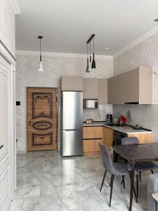 eine Küche mit einem Edelstahlkühlschrank und einem Tisch in der Unterkunft Luxury Leo Apartment Sevan in Sewan