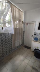 a room with a shower curtain and a door at Maison Lyne in Hammamet +4 photos
