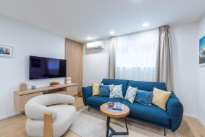 ein Wohnzimmer mit einer blauen Couch und einem Fernseher in der Unterkunft Guesthouse Casa Nova in Poreč