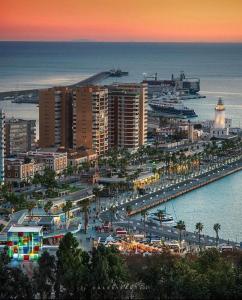 a city with a harbor and a marina at sunset at M-Room in Málaga