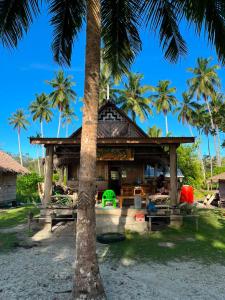 a resort with a palm tree in front of it at Mentawai Tribe Experience & Private Beach Camp in Pulau Masilo