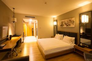 ein Schlafzimmer mit Bett, Schreibtisch und Fernseher in der Unterkunft Windyhill Hotel in Elâzığ