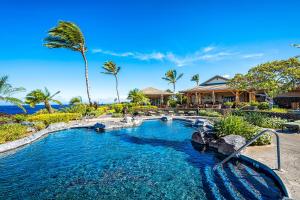 a pool at a resort with palm trees at Oceanfront Condo Halii Kai 14D in Waikoloa