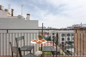 a balcony with a table and chairs on a roof at Maribeach3 Sitges in Sitges