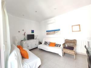 a living room with a white couch and a tv at Maribeach3 Sitges in Sitges