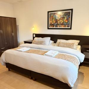 a bedroom with two beds and a painting on the wall at G6 Monoambiente King con Cochera en Villa Ángela in Villa Ángela