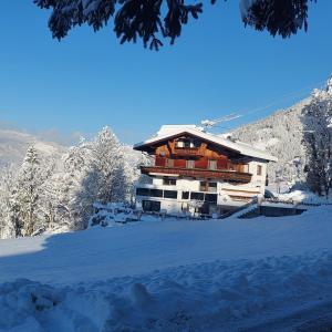 a building in the snow with snow covered trees at Haus Margret in Stummerberg