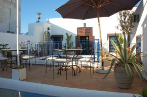 a patio with tables and chairs and an umbrella at Riad Dar Soufa in Rabat