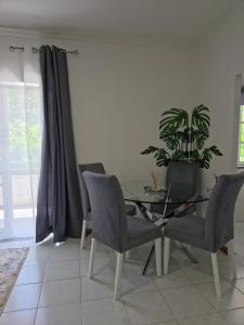 a dining room table with chairs and a potted plant at Garça-Real 2 in Vale de Madeiros