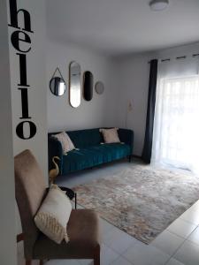 a living room with a blue couch and a rug at Garça-Real 2 in Vale de Madeiros