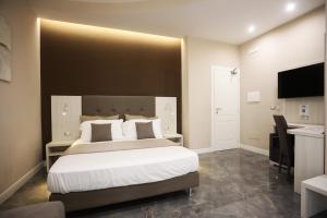 a bedroom with a large bed and a flat screen tv at DEDA & FOVE in Naples
