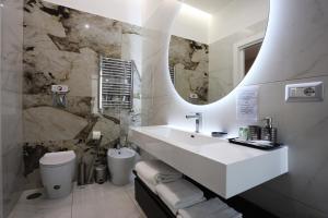 a white bathroom with a sink and a mirror at DEDA & FOVE in Naples