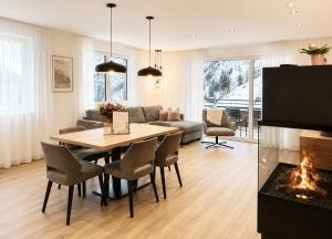 a living room with a table and a fireplace at Alpenstolz Damüls Haus 4 - Stilvoll urlauben in den Bergen in Damuls
