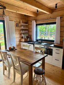 a kitchen with a wooden table and chairs in a cabin at Chata u Drwala Święta Lipka in Święta Lipka