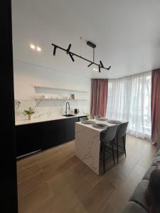 a kitchen and dining room with a table and chairs at Manhattan Comfort in Ivano-Frankivsk