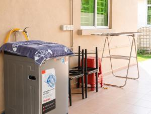 a room with a table and a refrigerator and a table at Family Retreat w Kid Pool, BBQ Games Sleeps 10pax Melaka in Kampong Beringin
