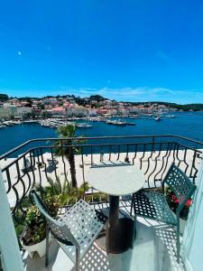a balcony with a table and chairs and a view of the water at Hotel Apoksiomen in Mali Lošinj