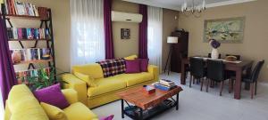 a living room with a yellow couch and a dining room at Hanem in Cedit