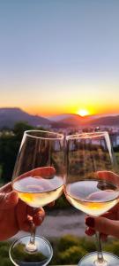 two people holding wine glasses with the sunset in the background at Hanem in Cedit