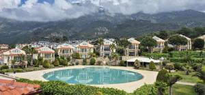 a resort with a large swimming pool and houses at Hanem in Cedit