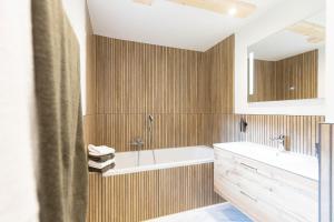 a bathroom with a tub and a sink and a mirror at Chalet Au in Fischen +22 photos