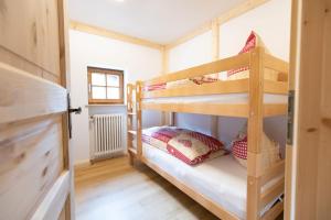 two bunk beds in a small room with a window at Chalet Au in Fischen