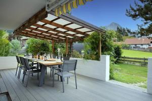 a patio with a table and chairs under a pergola at Chalet Au in Fischen