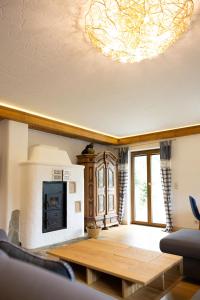 a living room with a table and a fireplace at Chalet Au in Fischen