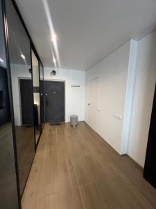 an empty room with a wooden floor and white walls at Manhattan Comfort in Ivano-Frankivsk +5 photos