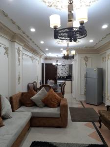 a living room with a couch and a kitchen at SARAYA AWAD HEGAZI STREET- families only in Alexandria