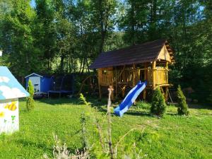 a playground with a slide and a house at Kolibaba in Dolný Kubín
