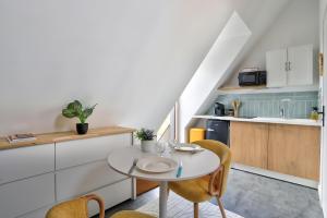 a kitchen with a table and chairs in a room at Gîte du Merlin in Plumergat