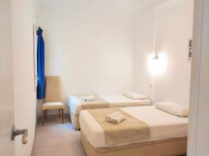 a room with two beds and a chair in it at Maribeach Sitges in Sitges