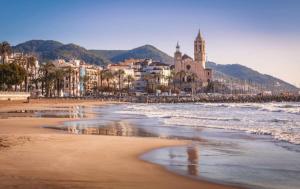 a view of a beach with buildings and the ocean at Maribeach Sitges in Sitges