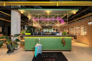 a restaurant with a green bar with a sign that reads unless to see you at Moxy Budapest Downtown in Budapest