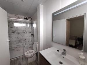 a bathroom with a toilet and a sink and a mirror at Maribeach2 Sitges in Sitges