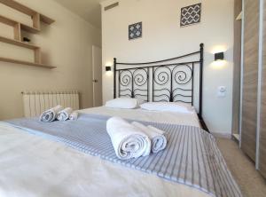 a bedroom with a bed with towels on it at Maribeach2 Sitges in Sitges