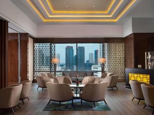 a lobby with chairs and a table and a large window at Raffles Jakarta in Jakarta +203 photos