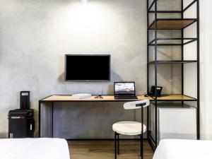 a desk with a computer and a laptop on it at ibis Ribeirao Preto Vila do Golf Shopping in Ribeirão Preto