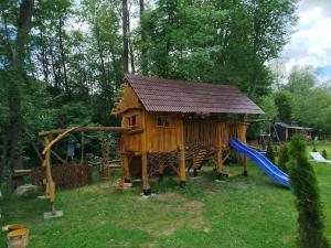 a wooden house with a slide and a playground at Kolibaba in Dolný Kubín +23 photos