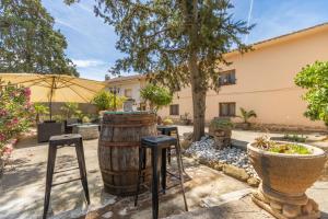 a patio with a barrel and stools at Casa Rural Cal Pallol in Camarasa