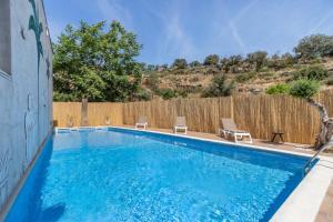 a swimming pool with two chairs and a fence at Casa Rural Cal Pallol in Camarasa