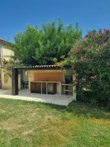 a house with a patio and a tree at L'Oustau de Maître Potager in Valréas
