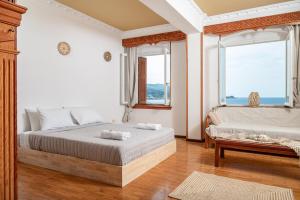 a bedroom with a bed and two windows at SeaView City in Samos