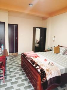 a bedroom with a large bed and a red desk at Arara ibt homestay in Cherrapunji