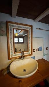 a bathroom sink with a mirror on a wooden counter at Casa rural Más La Torreta con vistas al Pla de Vistabella cerca del Peñagolosa Pet Friendly niños gratis in Vistabella del Maestrazgo +41 photos